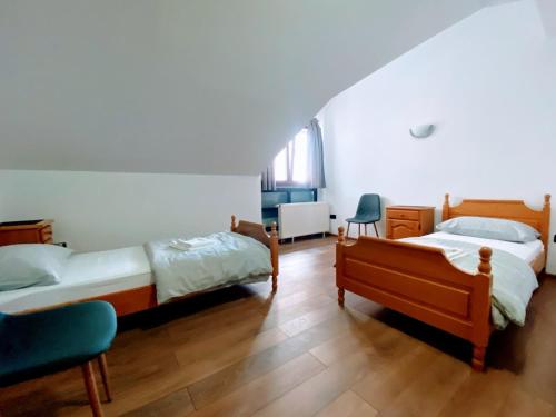 a bedroom with two beds and a chair at Motel Vujeva in Livno