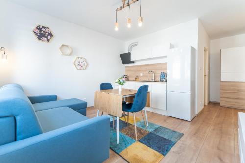 Apartament w Centrum في مينززدرويه: غرفة معيشة مع أريكة زرقاء وطاولة