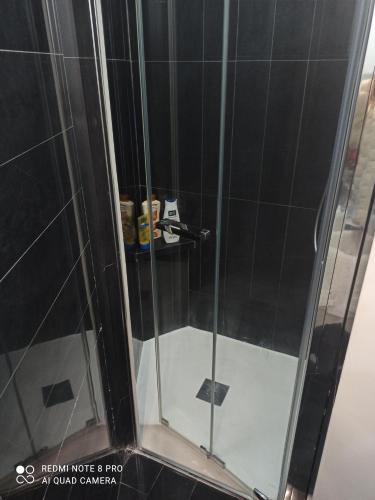 um chuveiro com uma porta de vidro na casa de banho em MEDUSA house em Taormina
