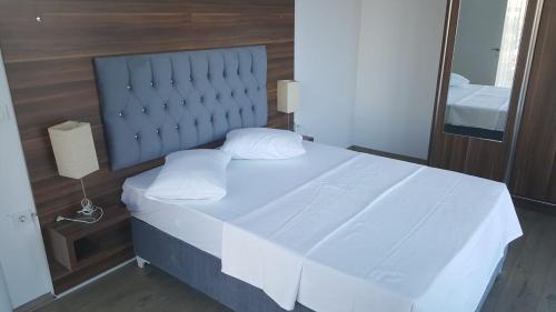 a white bed with a blue headboard and white pillows at Skyport Istanbul Hotel in Istanbul