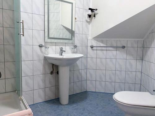 a bathroom with a sink and a toilet and a mirror at Motel Vujeva in Livno
