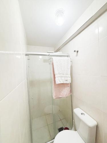 a white bathroom with a shower and a toilet at Refúgio Urbano in Brasilia
