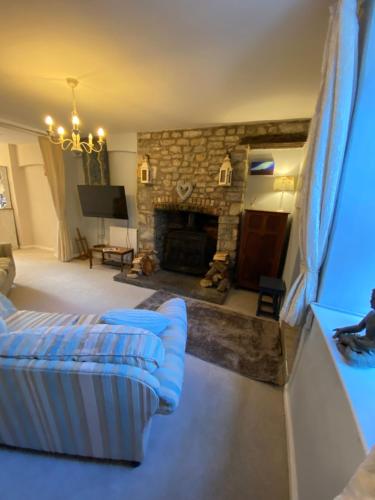 ein Wohnzimmer mit einem Sofa und einem Steinkamin in der Unterkunft The Prophecy of Light Retreat in Glastonbury