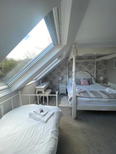 a bedroom with a white bed and a window at The Prophecy of Light Retreat in Glastonbury