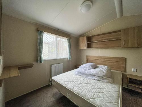 a bedroom with a bed and a window at Great Caravan For Hire By The Beach In Norfolk, By Hunstanton Beach Ref 13005l in Hunstanton