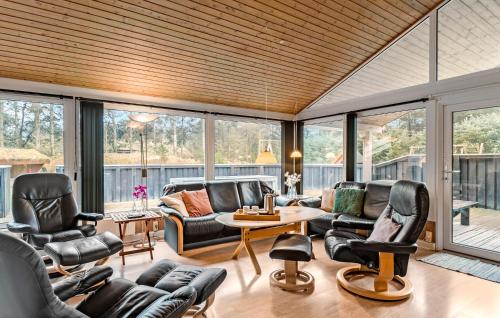 Elle comprend un salon doté d'un mobilier en cuir et de grandes fenêtres. dans l'établissement 4 Bedroom Beautiful Home In Saltum, à Saltum