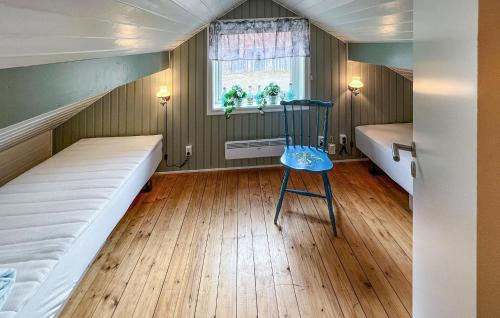 Habitación con 2 camas y una silla azul. en 3 Bedroom Lovely Home In Mellerud, en Mellerud