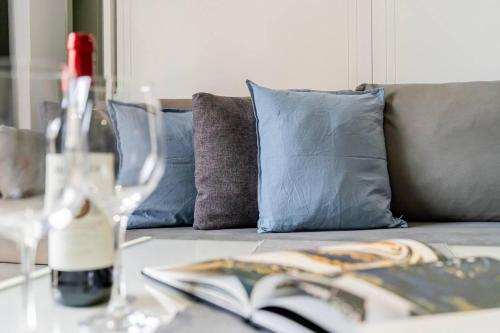 a couch with pillows and a book on a table at Loft con BALCÓN a CALLE MAYOR. Ideal PAREJAS in Madrid