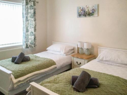 a bedroom with two beds and a window at Moor Close in Alne