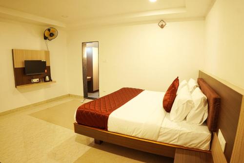 a hotel room with a bed and a television at GREEN MOUNT RESORTS in Malaiyāndipattanam