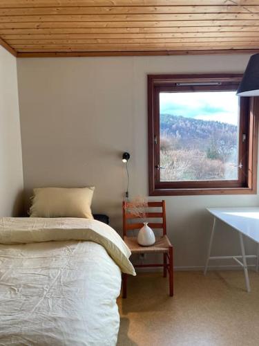 a bedroom with a bed and a window and a table at Spacious villa with view - 5BR - FREE parking - Great Wi-Fi in Bergen