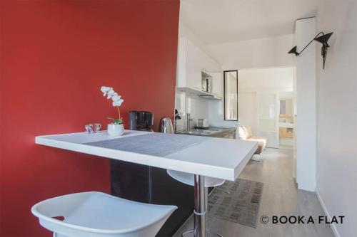 a kitchen with a white table and a red wall at Luxury studio in 5 minutes of the Champs-Elysées in Paris