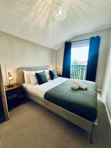 1 dormitorio con 1 cama grande y cortinas azules en Delightful 1-bed Apt with Free Parking and Wi-fi by HP Accommodation, en Milton Keynes