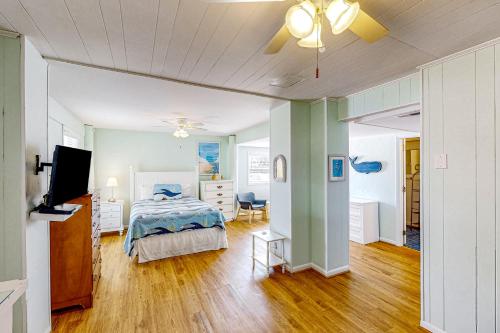 a bedroom with a bed and a ceiling fan at Cuddlefish in Virginia Beach