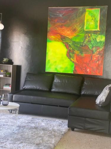 a black couch in a living room with a painting at B&B IL QUADRIFOGLIO in Iesi