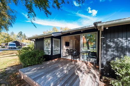 a house with a deck with glass doors at Hanmer Springs TOP 10 Holiday Park in Hanmer Springs
