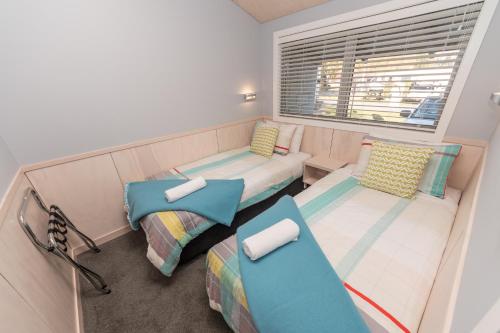 a small room with two beds and a window at Hanmer Springs TOP 10 Holiday Park in Hanmer Springs