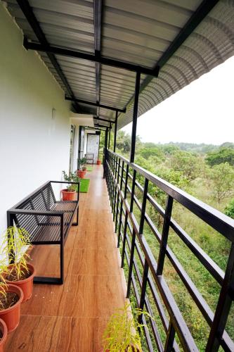 a balcony with benches and potted plants on it at GREEN MOUNT RESORTS in Malaiyāndipattanam