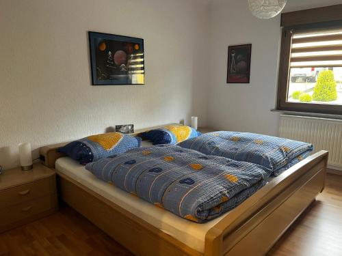 a bedroom with a bed with blue and yellow pillows at Ferienwohnung Schneider in Baumholder
