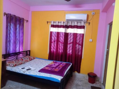 a bedroom with a bed with pink and yellow walls at The Orchid Inn in Kolkata