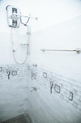 a bathroom with a shower with trees on the wall at Tango Sunrise Villa in Tangalle