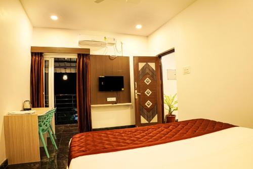 a hotel room with a bed and a television at GREEN MOUNT RESORTS in Malaiyāndipattanam