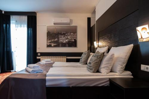 a hotel room with a large bed with white pillows at VILA COMO EN CASA - FREE PARKING in Sarajevo
