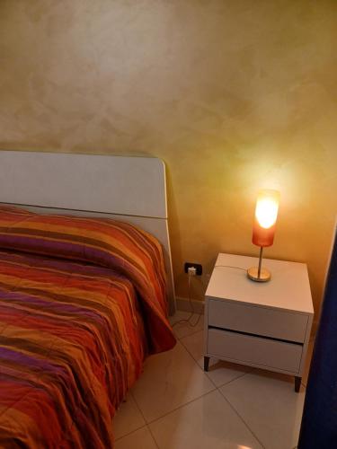 ein Schlafzimmer mit einem Bett und einer Lampe auf einem Nachttisch in der Unterkunft B&B Soleil in Nicosia