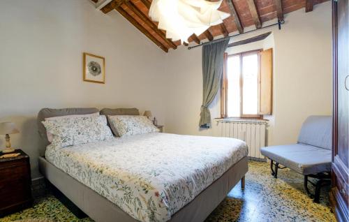 a bedroom with a bed and a chair and a window at Pet Friendly Apartment In C, Val Di Cecina With Kitchen in Castelnuovo di Val di Cecina