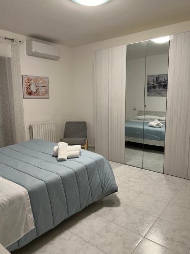 a bedroom with a blue bed and a chair at Casa di RO' in Taranto