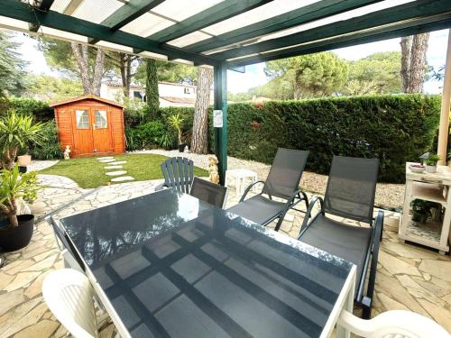 une table et des chaises sur une terrasse avec pergola dans l'établissement Charmant T3 Mezzanine 6 pers, Piscine, Parking, Jardin Calme, Proche Plage et Commerces - FR-1-607-106, au Cap d'Agde