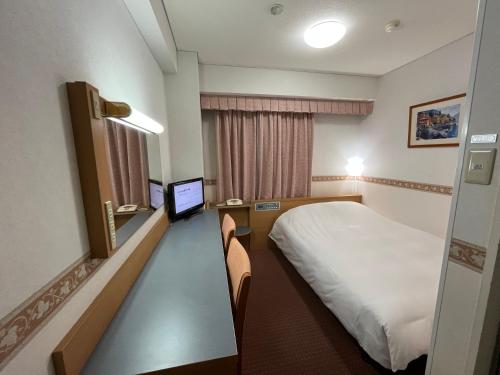 pokój hotelowy z łóżkiem i telewizorem w obiekcie Hotel Alpha-One Marugame w mieście Marugame