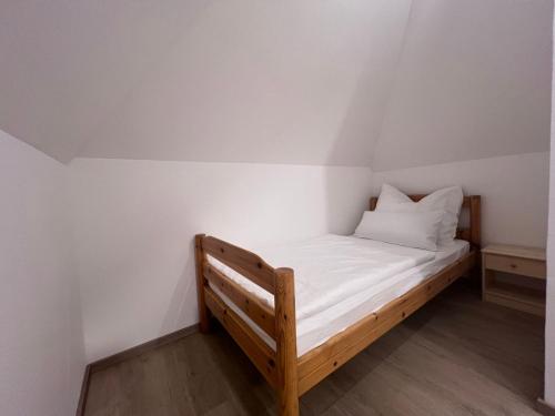 a small bed in a room with white walls at Ort 245 in Ried im Innkreis