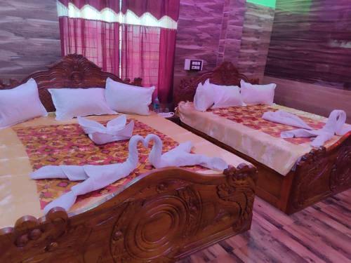 Dos camas con cisnes en una habitación en Hotel Paradise, en Mandarmani