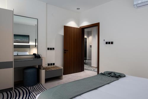 a bedroom with a bed and a desk and a mirror at فندق لفيف الخالدية - Lafif Hotel Al-Khaldia in Al Madinah