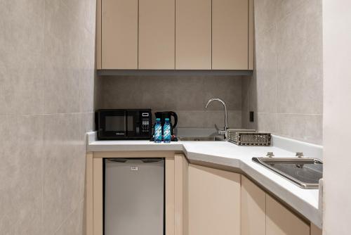 a kitchen with a microwave and a sink at فندق لفيف lviv hotel in Al Madinah