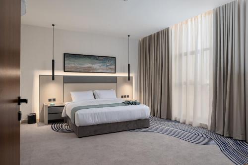 a bedroom with a bed and a large window at فندق لفيف الخالدية - Lafif Hotel Al-Khaldia in Al Madinah