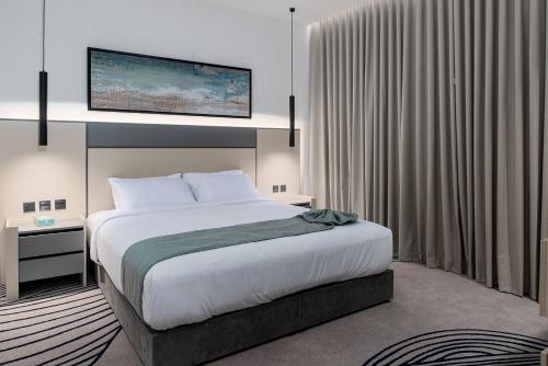 a bedroom with a large bed and a large window at فندق لفيف الخالدية - Lafif Hotel Al-Khaldia in Al Madinah