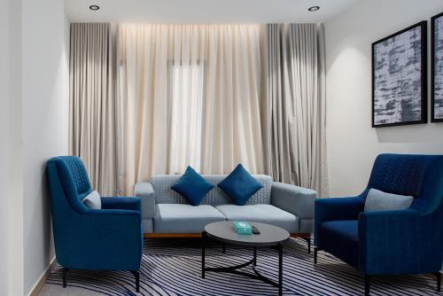 a living room with a couch and two blue chairs at فندق لفيف الخالدية - Lafif Hotel Al-Khaldia in Al Madinah