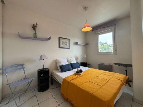 une chambre avec un lit avec une couverture jaune dessus dans l'établissement Appartement 2 pièces proche commerces à Mandelieu-la-Napoule - FR-1-609-70, à Mandelieu-la-Napoule