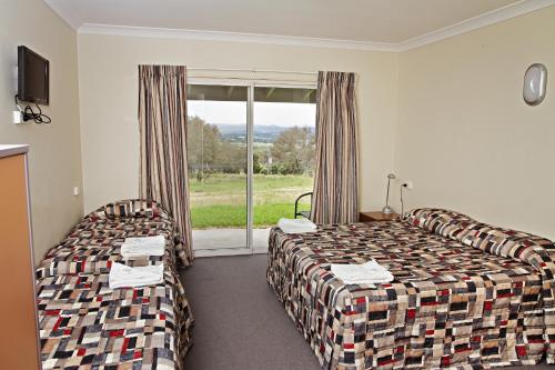 una camera d'albergo con due letti e una finestra di BATHURST GOLDFIELDS MOTEL at 428 CONROD STRAIGHT MOUNT PANORAMA a Bathurst