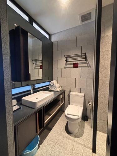 a bathroom with a toilet and a sink at Scarletz Comfy Suites KLCC by MOMO in Kuala Lumpur