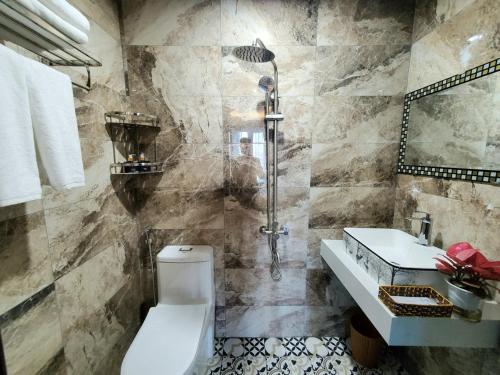 een badkamer met een douche, een toilet en een wastafel bij Hanoian Hotel in Dại Mõ