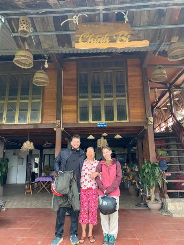 eine Gruppe von drei Personen, die vor einem Gebäude stehen in der Unterkunft Homestay Chinh Bi in Yên Bái