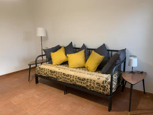 un sofá con almohadas amarillas y negras. en Paradisa30 - Zona Ospedale Cisanello, en Pisa