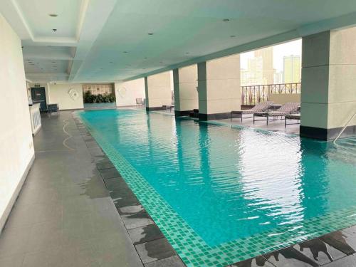 ein Pool in einem Gebäude mit blauem Wasser in der Unterkunft Hotel & Karaoke - Jianna's Place in Manila