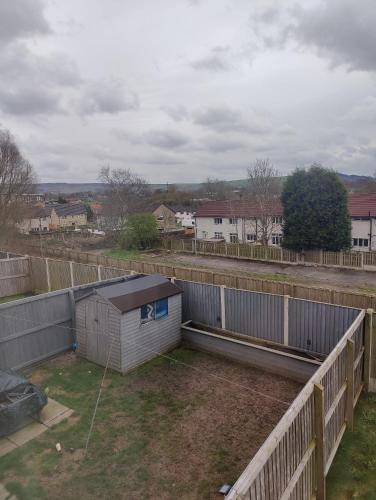 an empty backyard with a fence and a shed at Sgt Mark Stansfield Way in Mottram