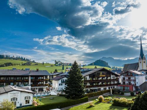 a town in the mountains with a church at Genuss - und Vitalhotel Moisl in Abtenau