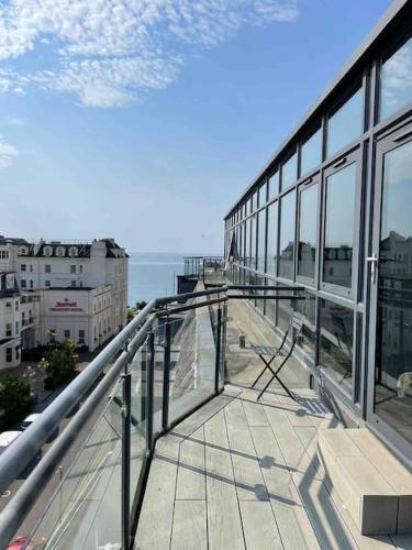 a balcony of a building with a view of the ocean at Beach Penthouse Apartment Bournemouth in Bournemouth