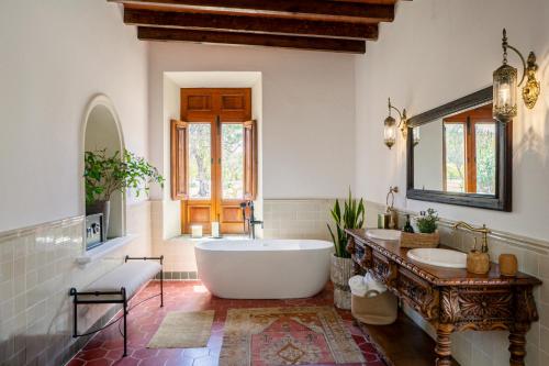 a large bathroom with a tub and two sinks at Hotel Boutique Viñedo Los Remedios in San Miguel de Allende